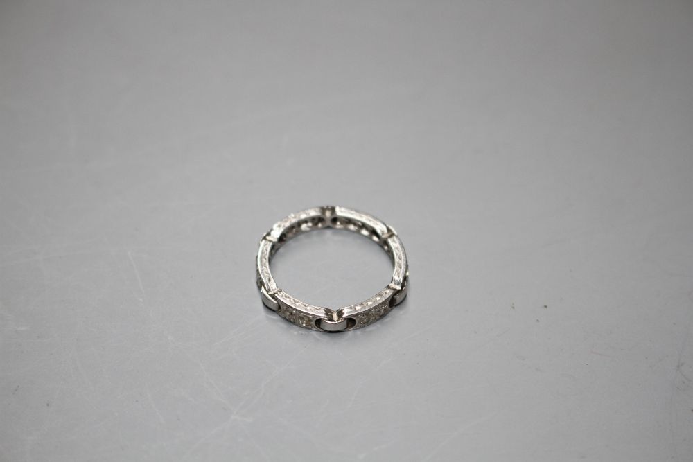 An unusual white metal (stamped Plat) and twelve stone diamond set eternity ring,